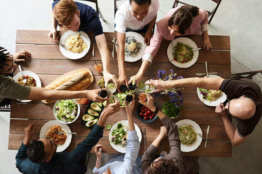 Imagen de grupo de persona compartiendo una comida alrededor de una mesa